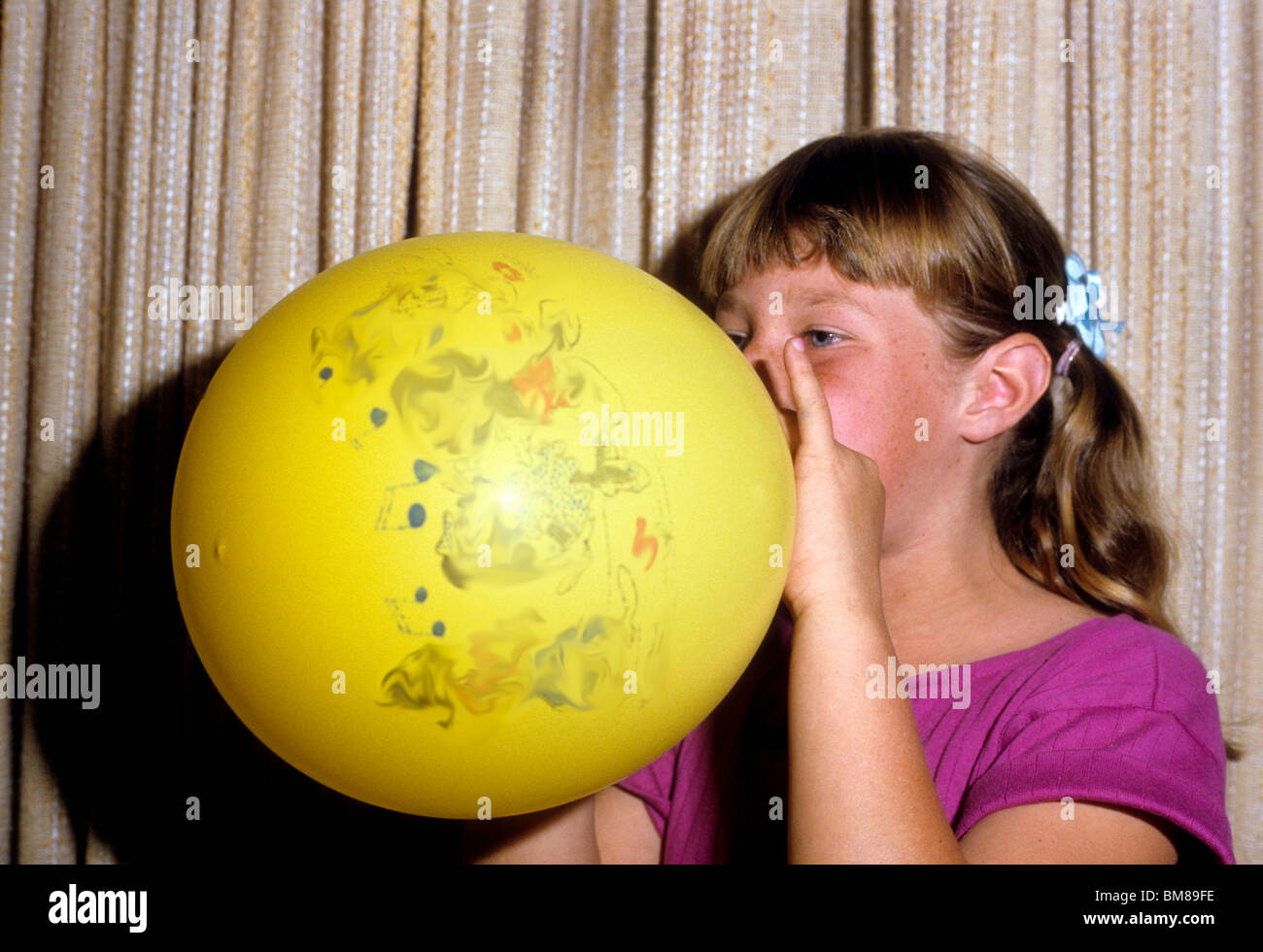 Girl éclate grand ballon jaune jouet jouer fun souffle poumons respirer  Photo Stock - Alamy