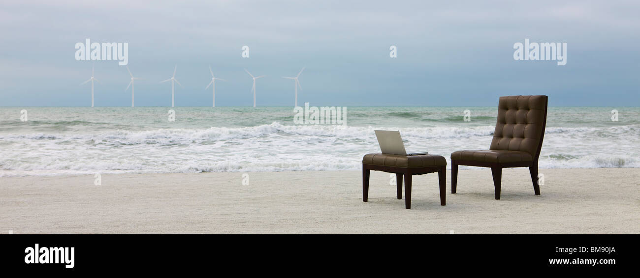 Président et un ordinateur portable sur la plage, les éoliennes visibles à distance Banque D'Images