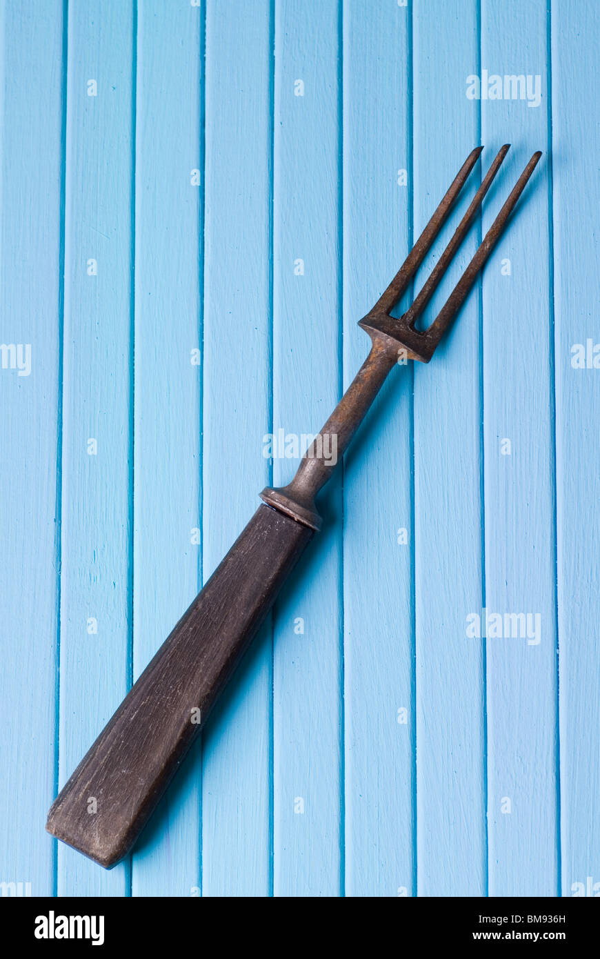 Old fashioned rouillé de fourche sur un fond de bois bleu Banque D'Images