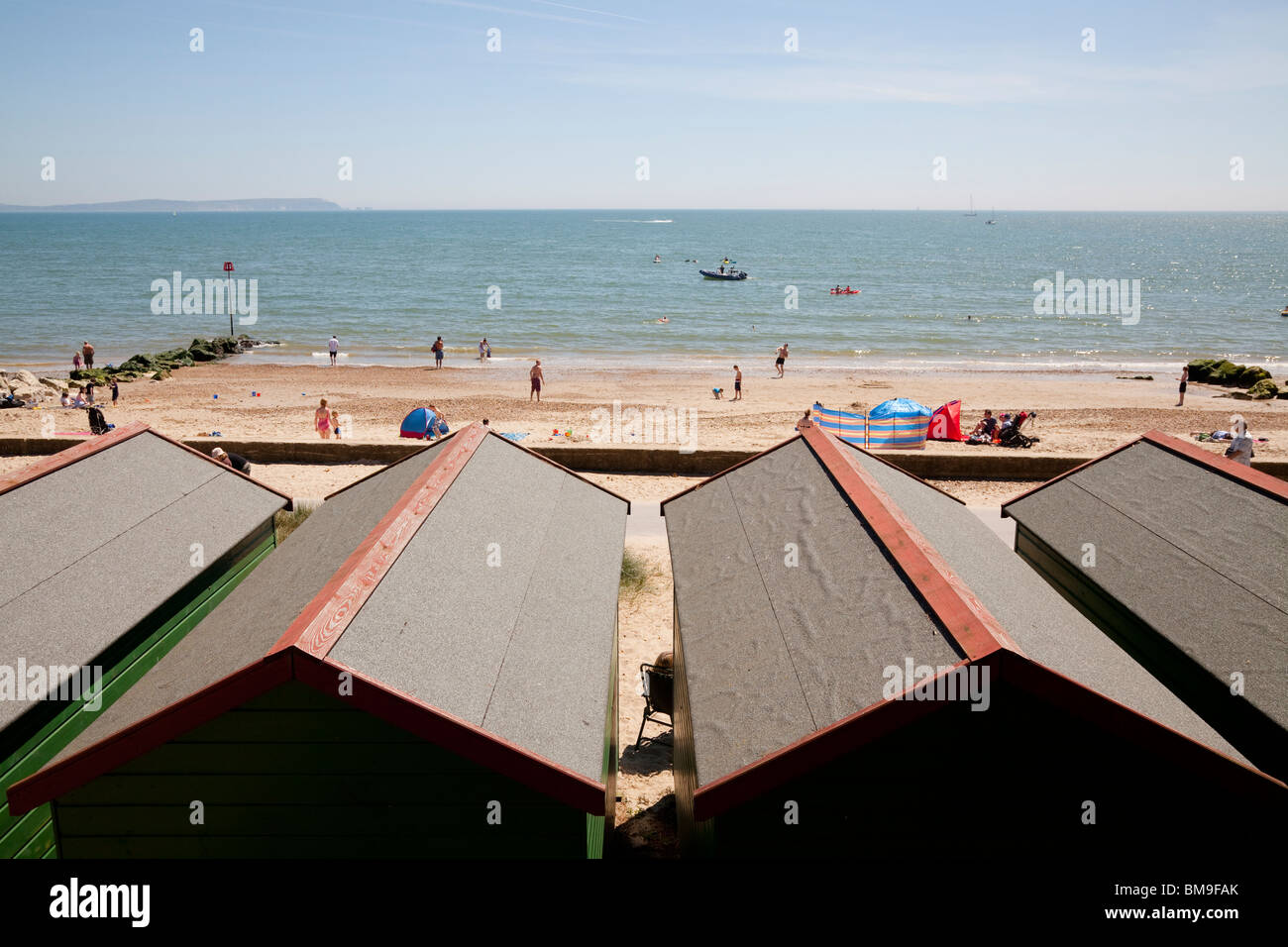 À la cabane de plage sur la plage et la mer vers les toits à Mudeford Banque D'Images