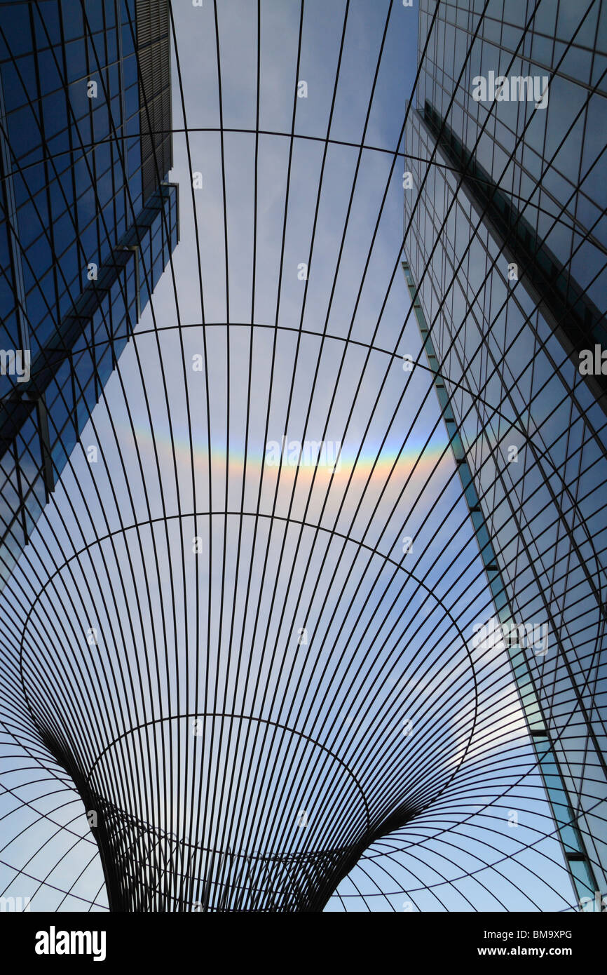Partie d'un arc-en-ciel circulaire dans le ciel au-dessus de London Docklands vue par un fil à l'extérieur de la sculpture siège de KPMG. Banque D'Images