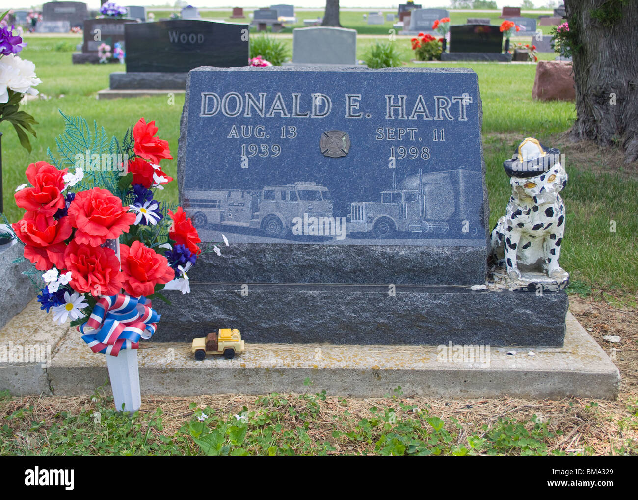 Le monument funéraire des pompiers dans un cimetière de Fairmount, Indiana, rend hommage à un pompier local avec une statue détaillée et un hommage de pierre tombale. Banque D'Images
