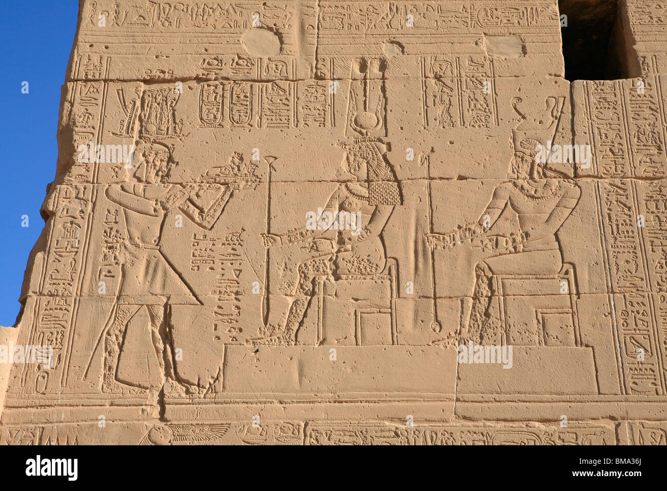 Un dégradé bas relief de la déesse égyptienne Hathor, Pharaon Ptolémée sur la façade du temple d'Isis à Philae (Île Agilka) en Egypte Banque D'Images