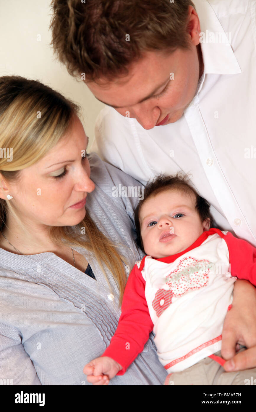 Jeune Famille Avec Un Bebe Les Parents A Garder Leur Enfant Dans Ses Bras Avec Amour Photo Stock Alamy