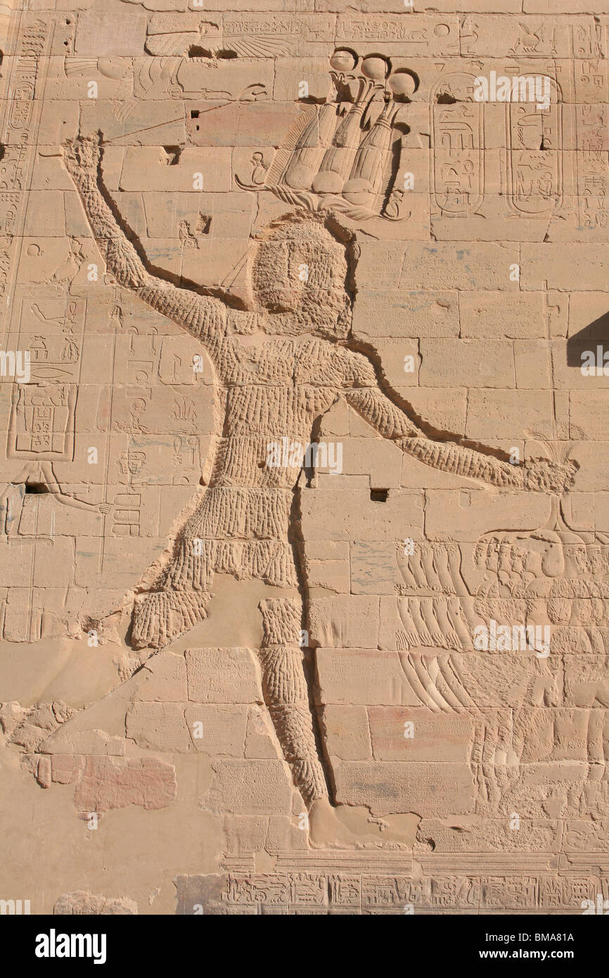 Un bas-relief du pharaon Ptolémée défiguré par les premiers chrétiens sur la façade du premier pylône du Temple de Philae, Egypte Banque D'Images