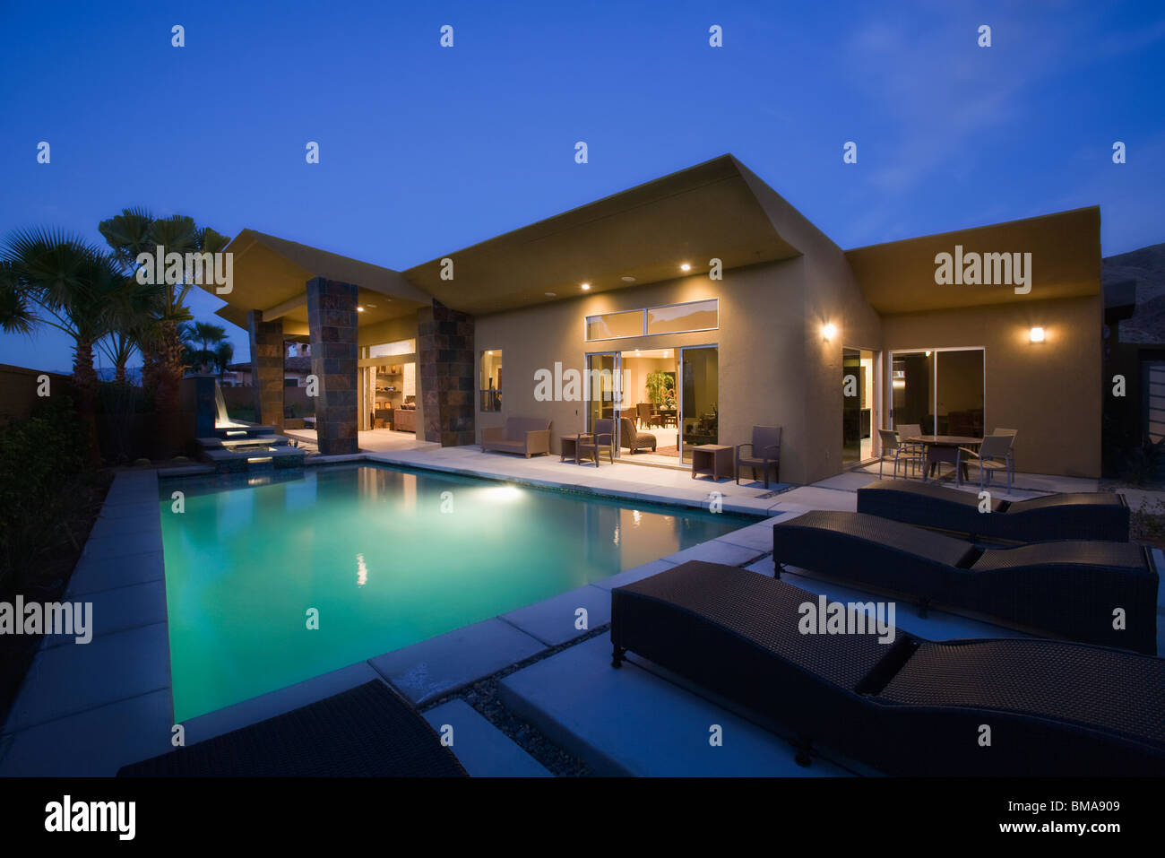 Piscine éclairée la nuit extérieur de maison et Banque D'Images