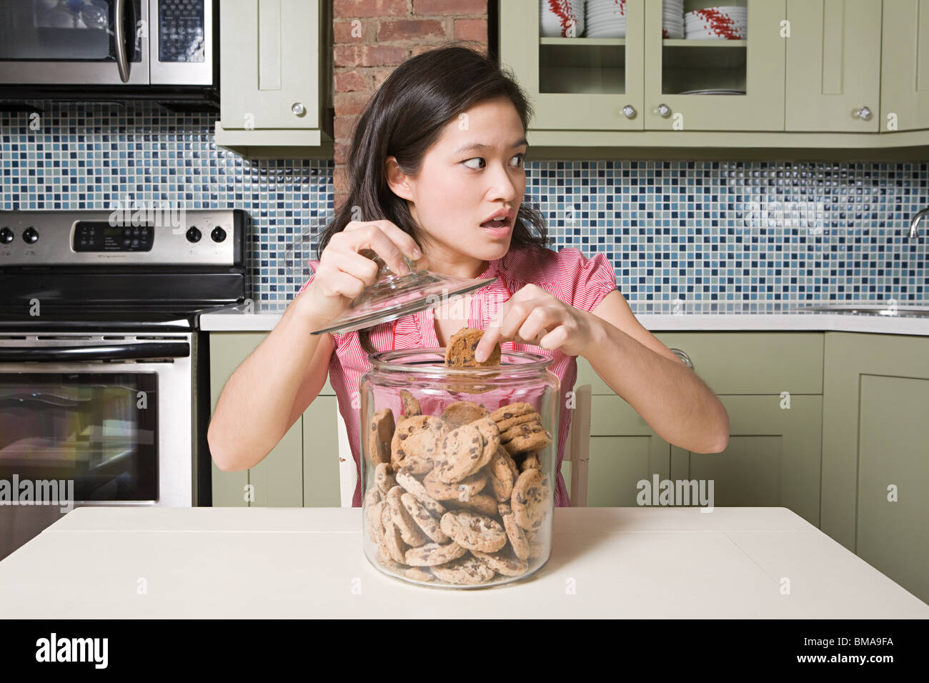 Jeune femme avec cookie jar Banque D'Images