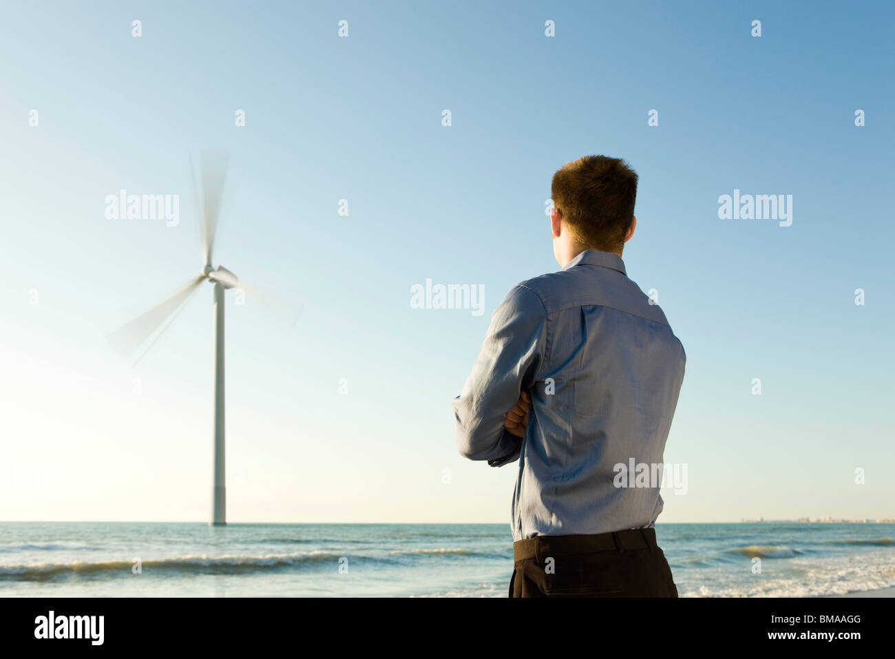 Man on beach offshore wind turbines d'observation au travail Banque D'Images Man on beach offshore wind turbines d'observation au travail Banque D'Images