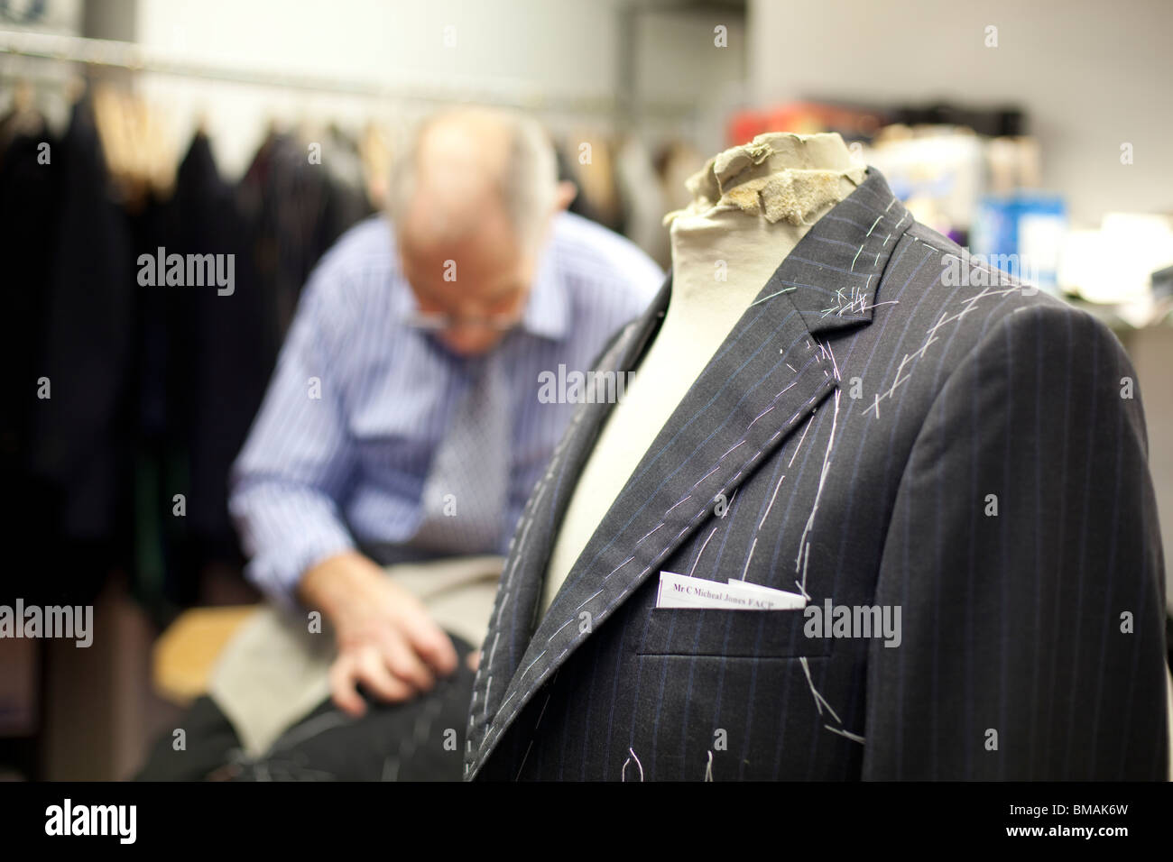 Un tailleur dans l'atelier d'Henry Poole dans Savile Row, Londres. Banque D'Images
