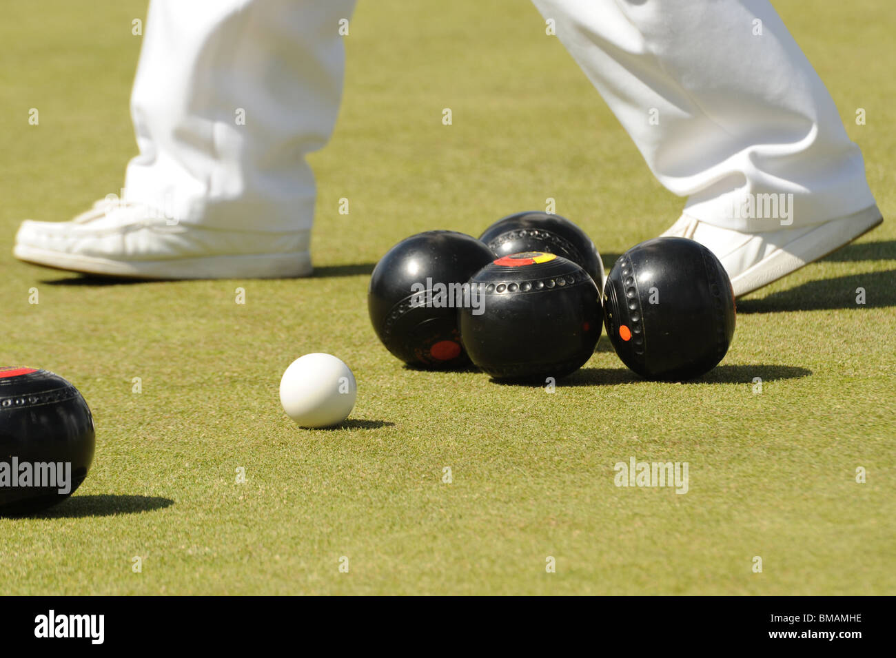 Une photographie de boules sur pelouse, avec un joueurs pieds dans l'arrière-plan Banque D'Images