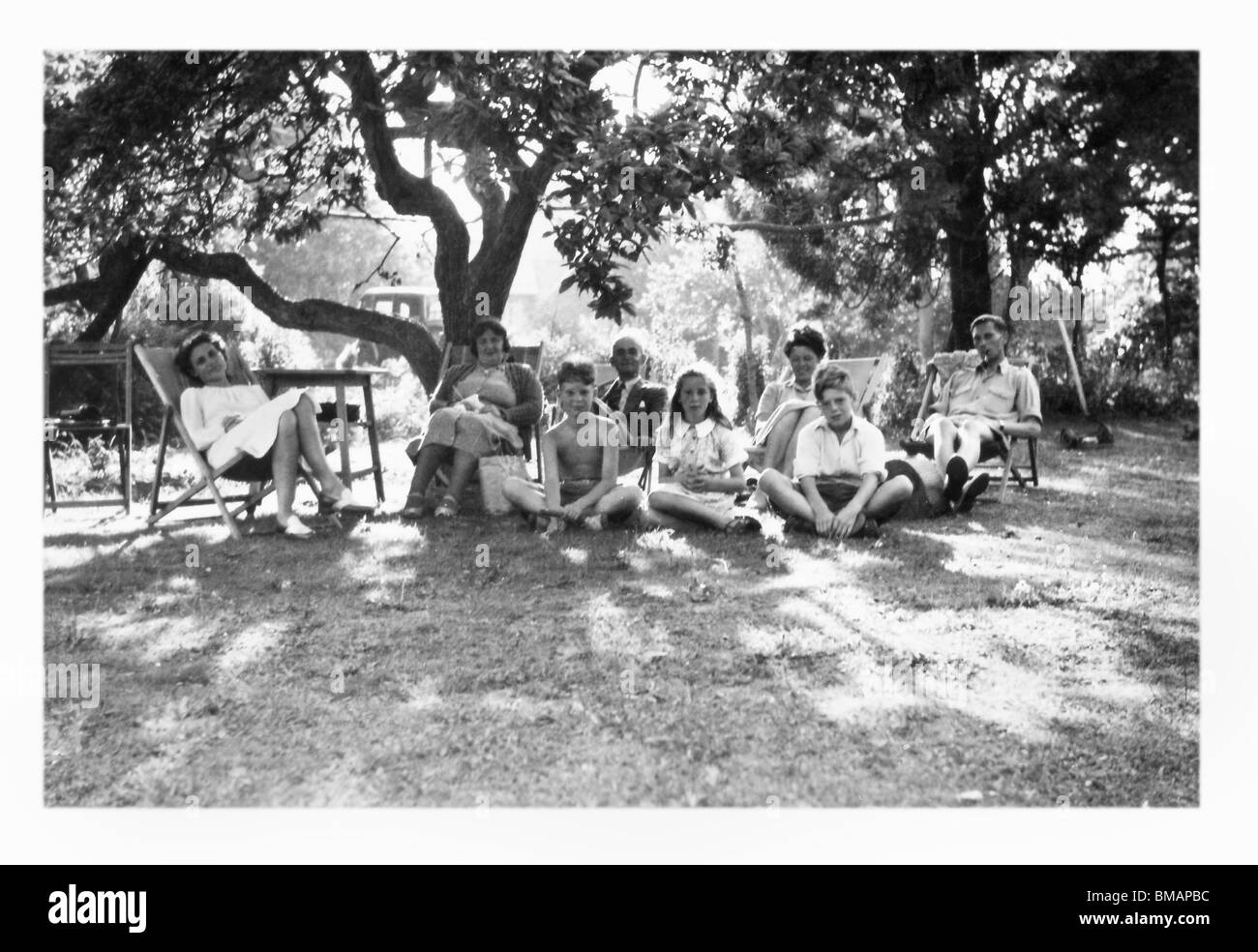Archives Photos : groupe Famille assis sur pelouse, à l'été (c1945) Banque D'Images