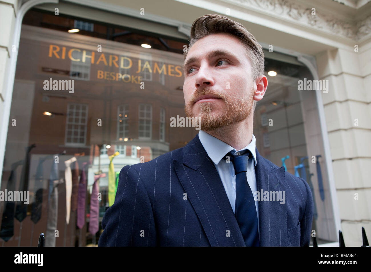 Un tailleur assistant se place en dehors de Richard James shop à Savile Row, Londres. Banque D'Images
