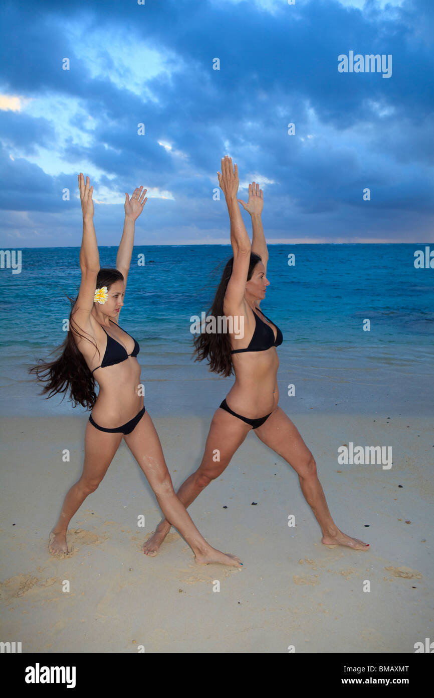 Mère et fille sur la plage à Hawaii au lever du soleil Banque D'Images