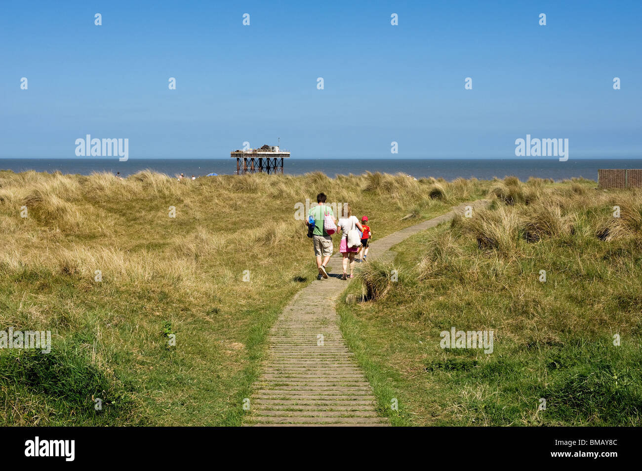 Une famille de marcher le long d'un chemin menant à la plage de Sizewell dans le Suffolk. Photo par Gordon 1928 Banque D'Images