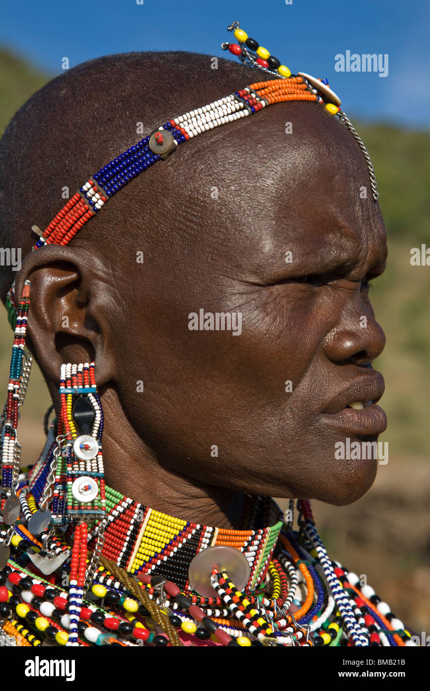 Close-up portrait profil femme Masai mature avec le trou de l'oreille portant des costumes traditionnels tribaux collier boucles d'Maasai Mara Banque D'Images