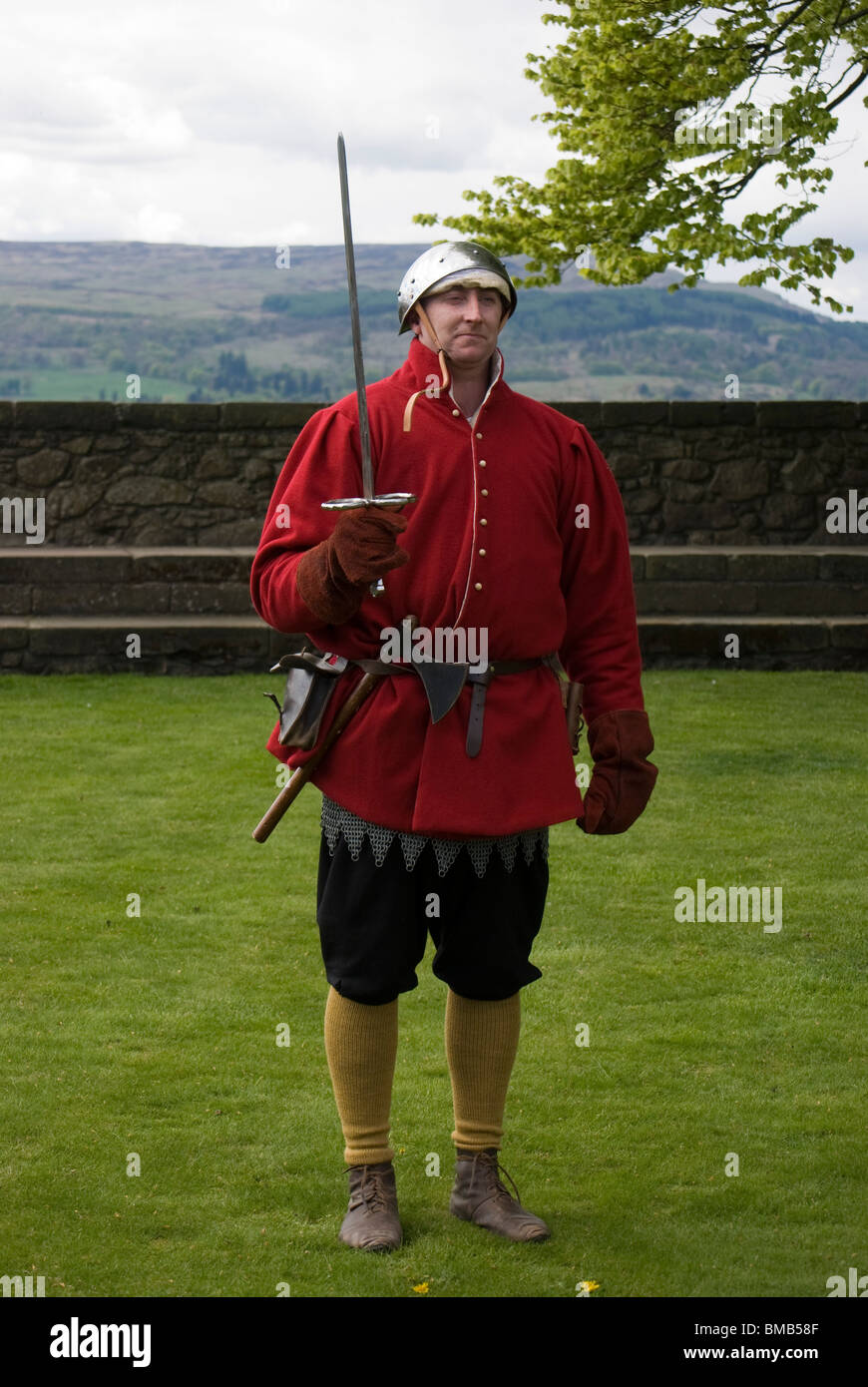 16e siècle soldat écossais de la garde tenant une épée, le cadre d'un événement historique au château de Stirling, Écosse. Banque D'Images