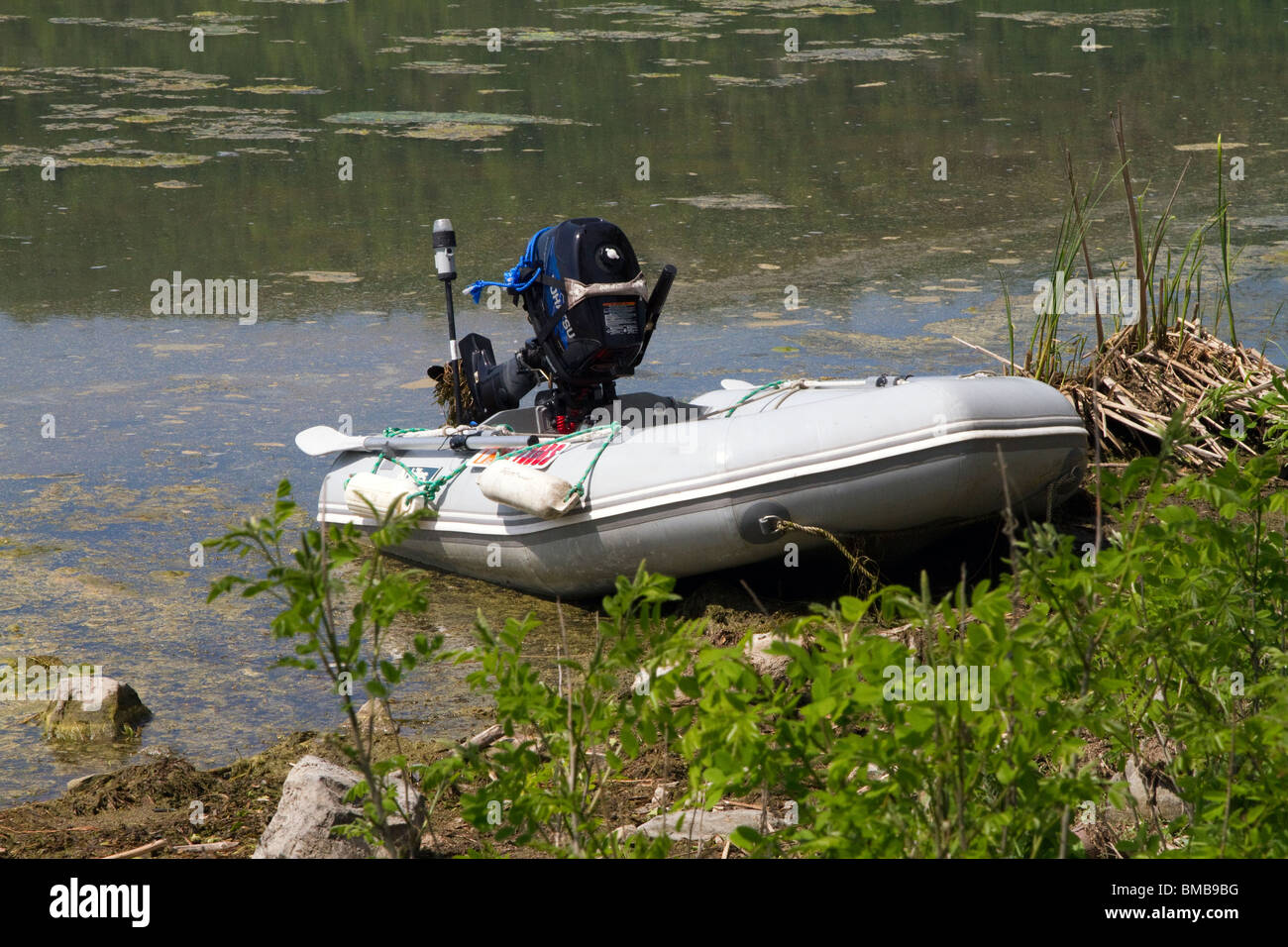 Échoués sur un bateau gonflable avec moteur hors-bord large et avirons. Banque D'Images
