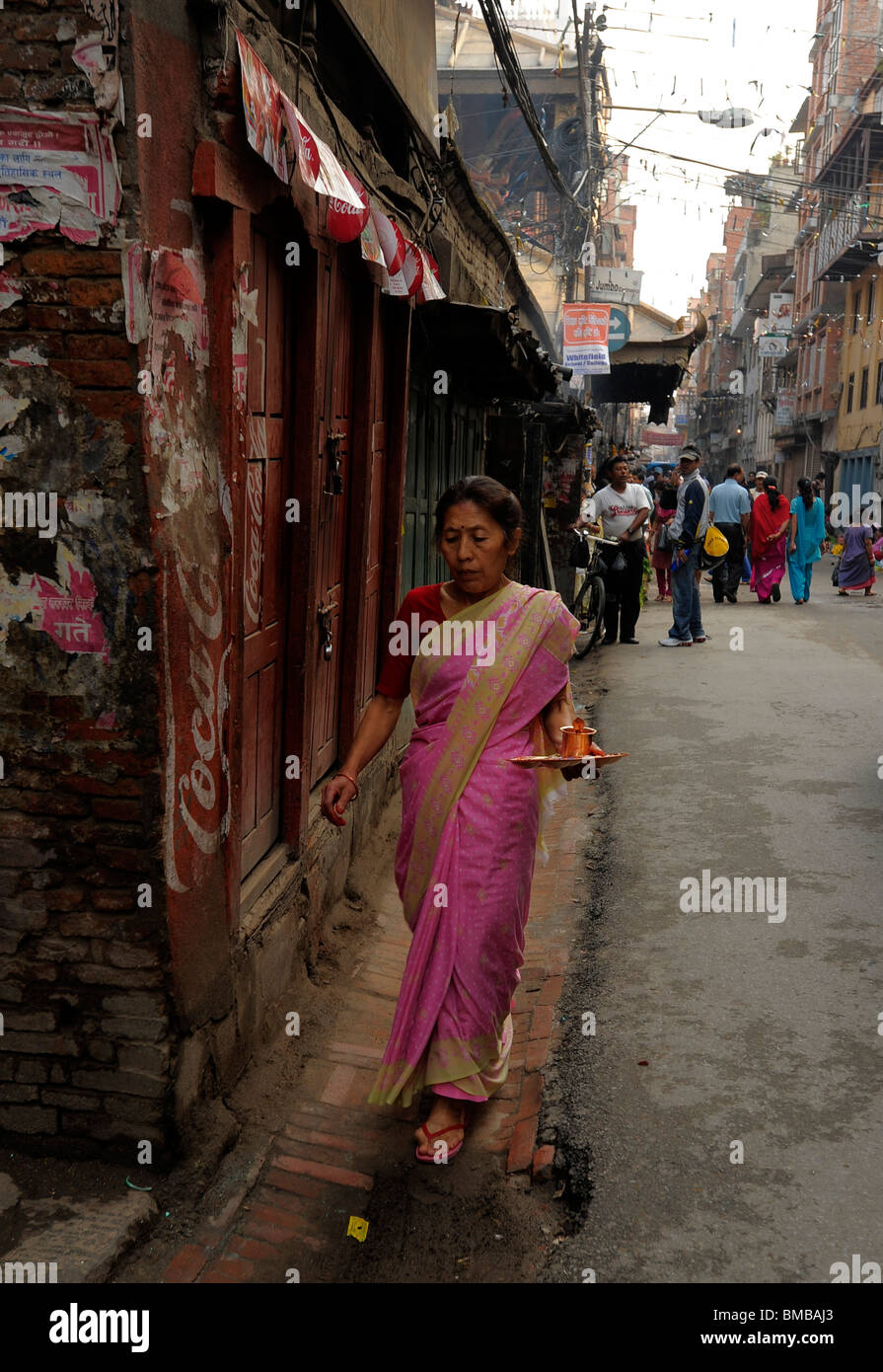 Vieille dame hindou népalais , matin adorant et en priant le rituel, rue latérale, à proximité de Durbar Square, Katmandou, Népal Banque D'Images