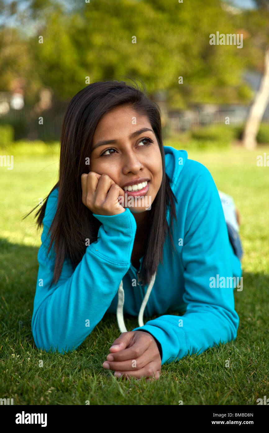 16 ans Hispanic American girl.thoughtful rêver penser assis herbe vue avant M. © Myrleen Pearson Banque D'Images