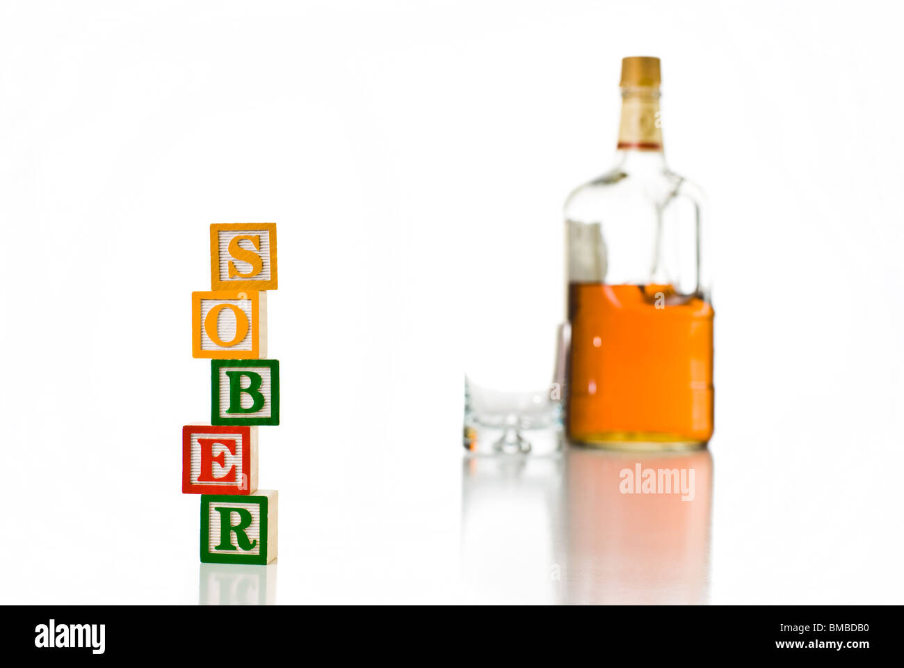 Enfants colorés blocks spelling relativement sobre avec une bouteille d'alcool et de verre Banque D'Images