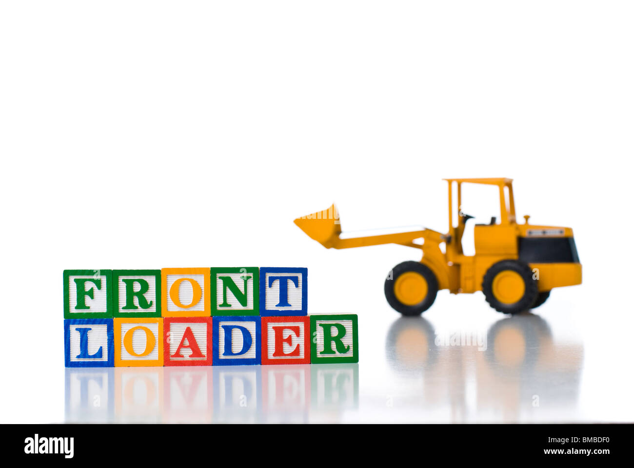 Enfants colorés blocks spelling CHARGEUR FRONTAL avec un jouet tracteur Banque D'Images