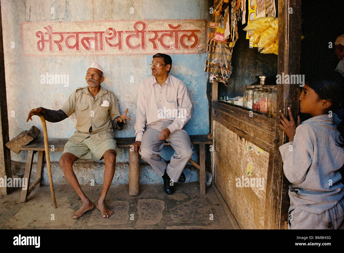 Deux hommes ayant une conversation dans un magasin de thé dans la ville de Panchgani, dans la région des Ghats occidentaux, dans l'État de Maharashtra, en Inde. Banque D'Images