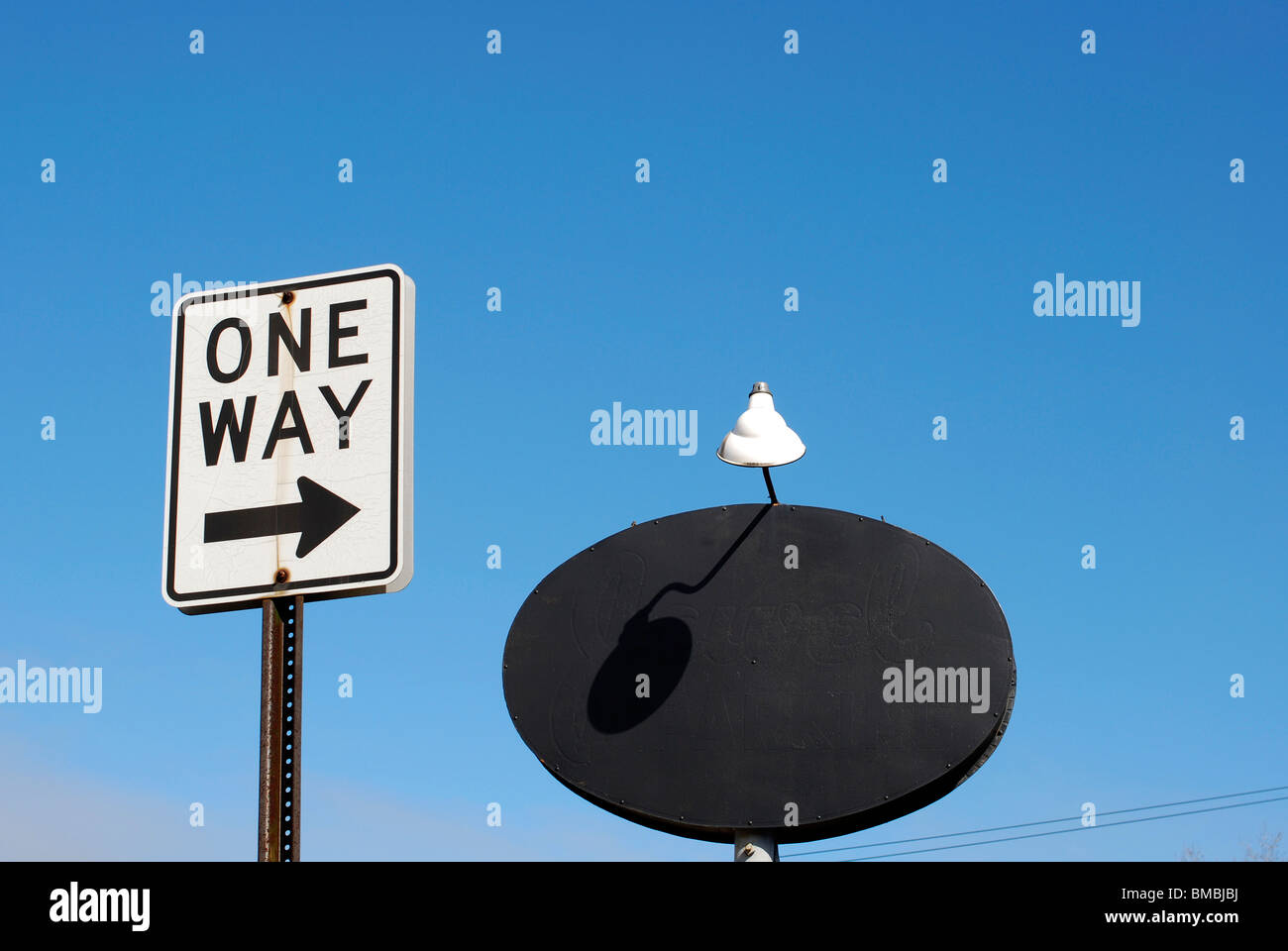 Une façon street sign et enseigne avec lampe contre le ciel bleu Banque D'Images