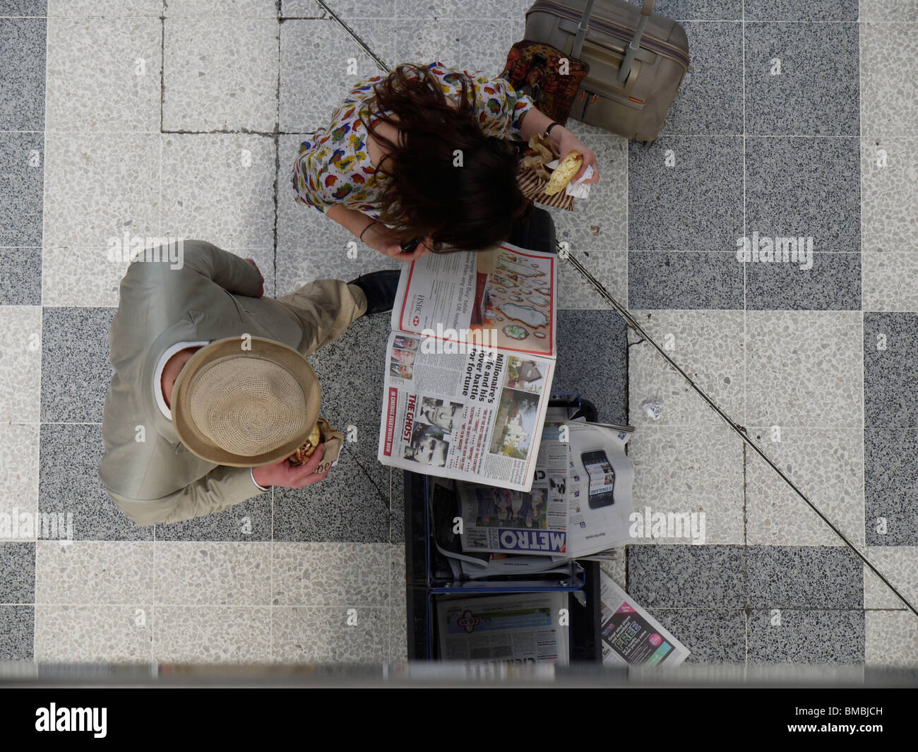 Vue aérienne des navetteurs lisant le journal gratuit du métro de Londres à la gare de Liverpool Street à Londres, Royaume-Uni, pendant l'heure de pointe du matin Banque D'Images