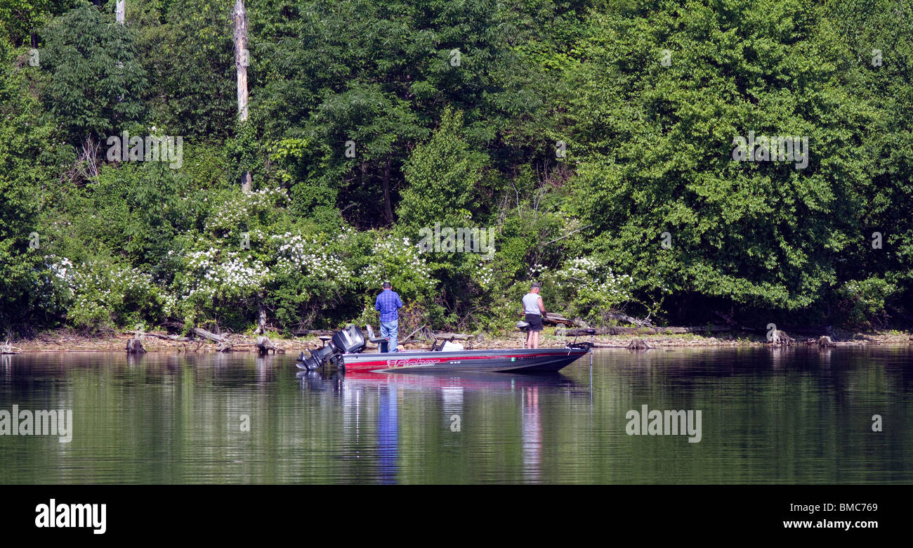 Deux pêcheurs bass bass dans un bateau de pêche le long de la rive. Banque D'Images