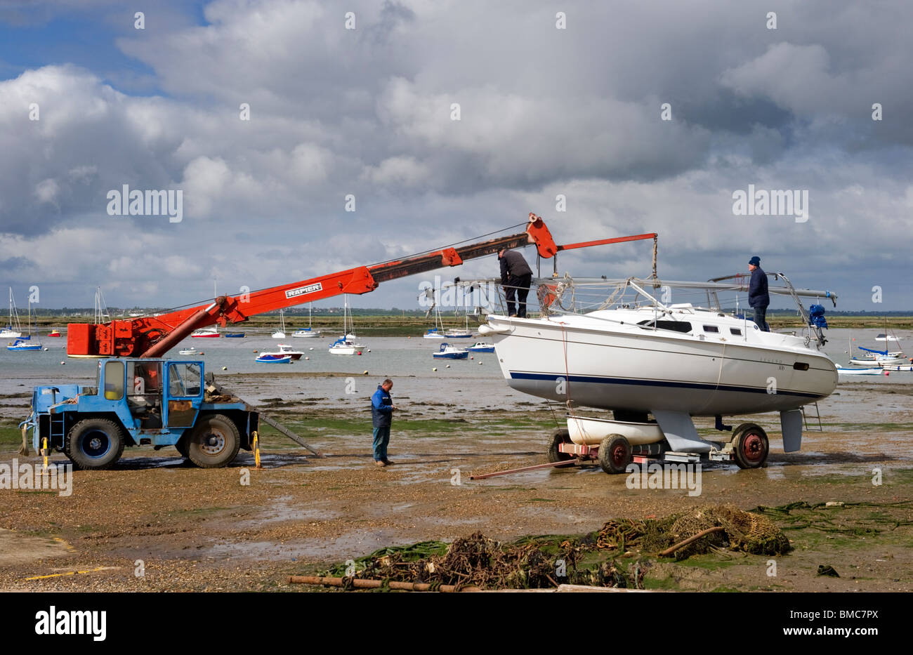 Entretien de bateaux sur la plage à marée basse sur l'île britannique Essex Mersea Banque D'Images