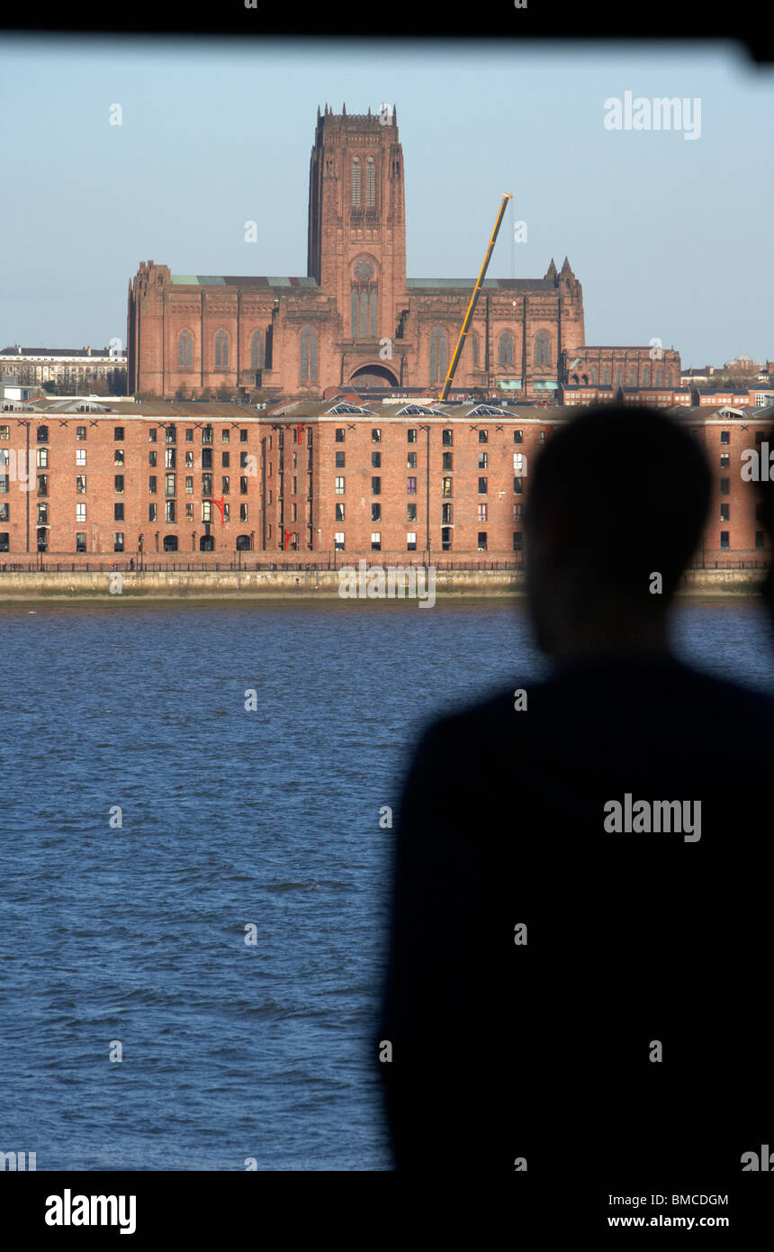 Passager donne de ferry d'anciens entrepôts sur liverpool waterfront rivage avec liverpool Anglican Cathedral Banque D'Images