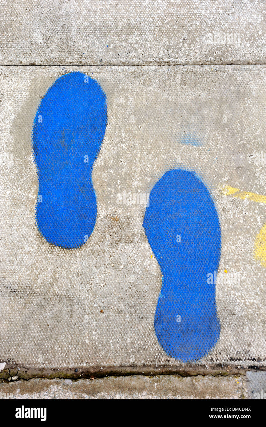 Peint sur la chaussée Blue footprints Banque D'Images