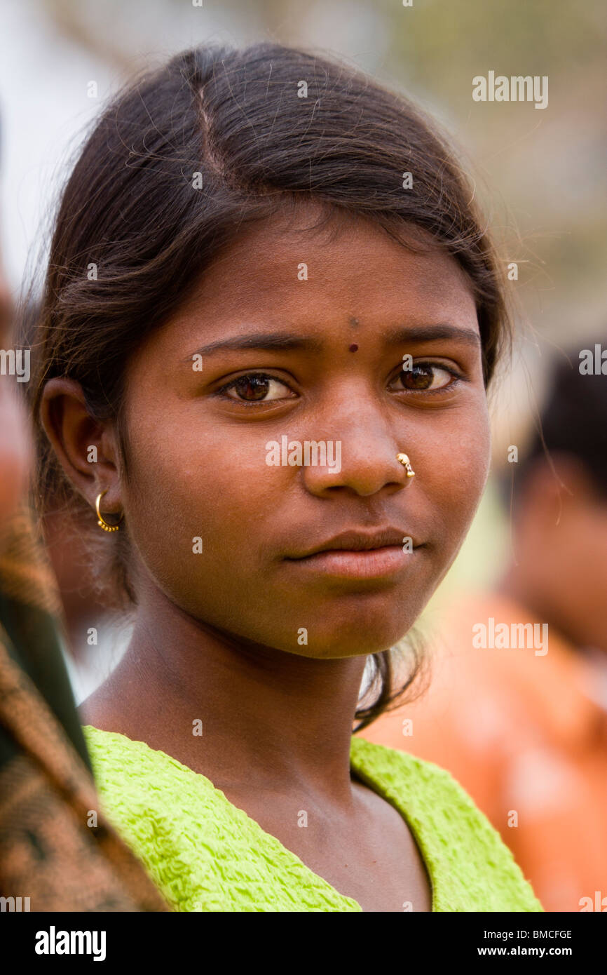 Closeup Portrait of attractive young female ethniques pénétrant la peau foncée yeux foncés cheveux noirs face à poser profil d'oreilles en or Banque D'Images
