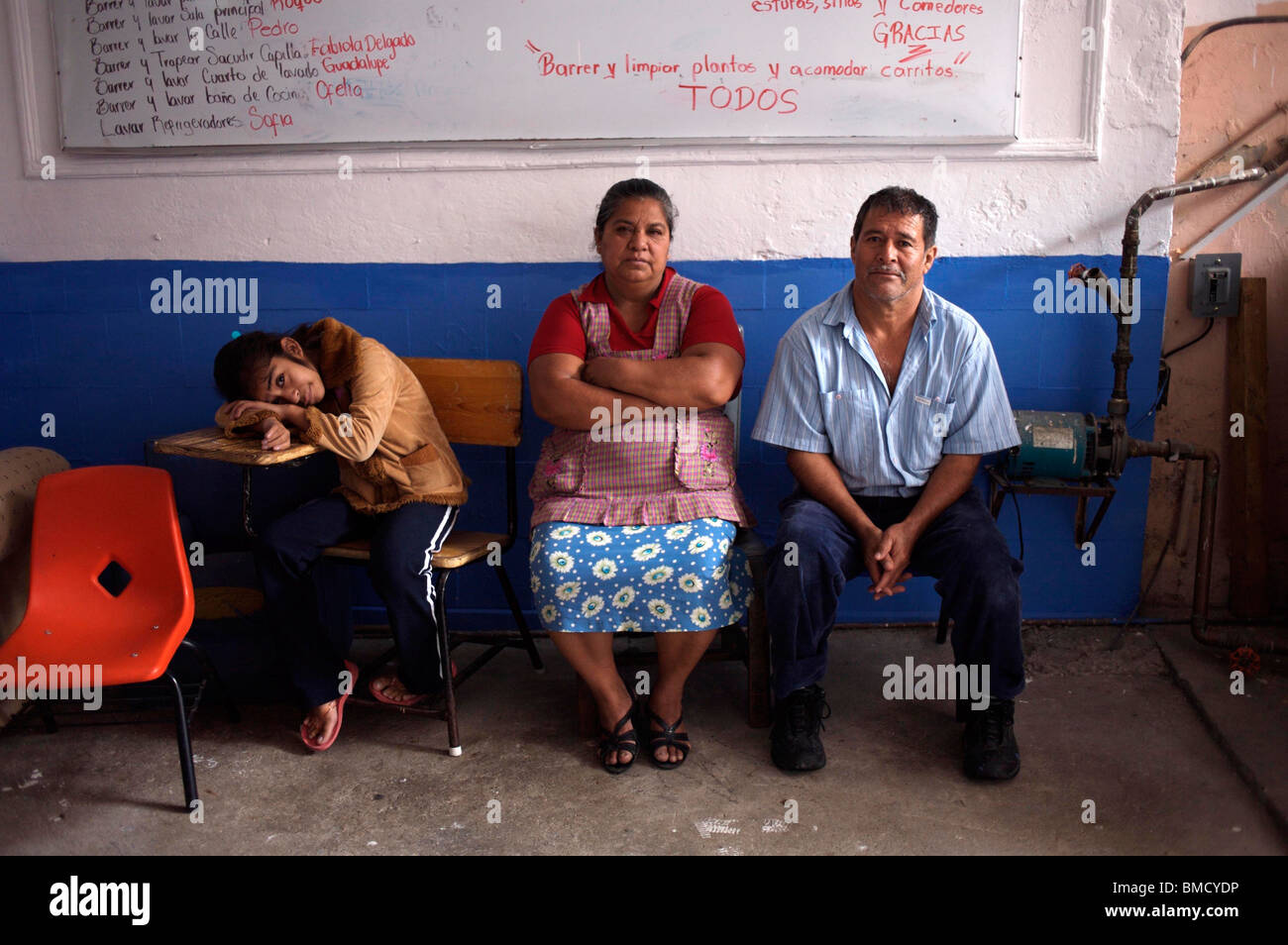 Une jeune fille se tient avec ses parents dans un foyer pour enfants souffrant d'exécuter par le clou de fondation dans la ville de Mexico. Banque D'Images Une jeune fille se tient avec ses parents dans un foyer pour enfants souffrant d'exécuter par le clou de fondation dans la ville de Mexico. Banque D'Images