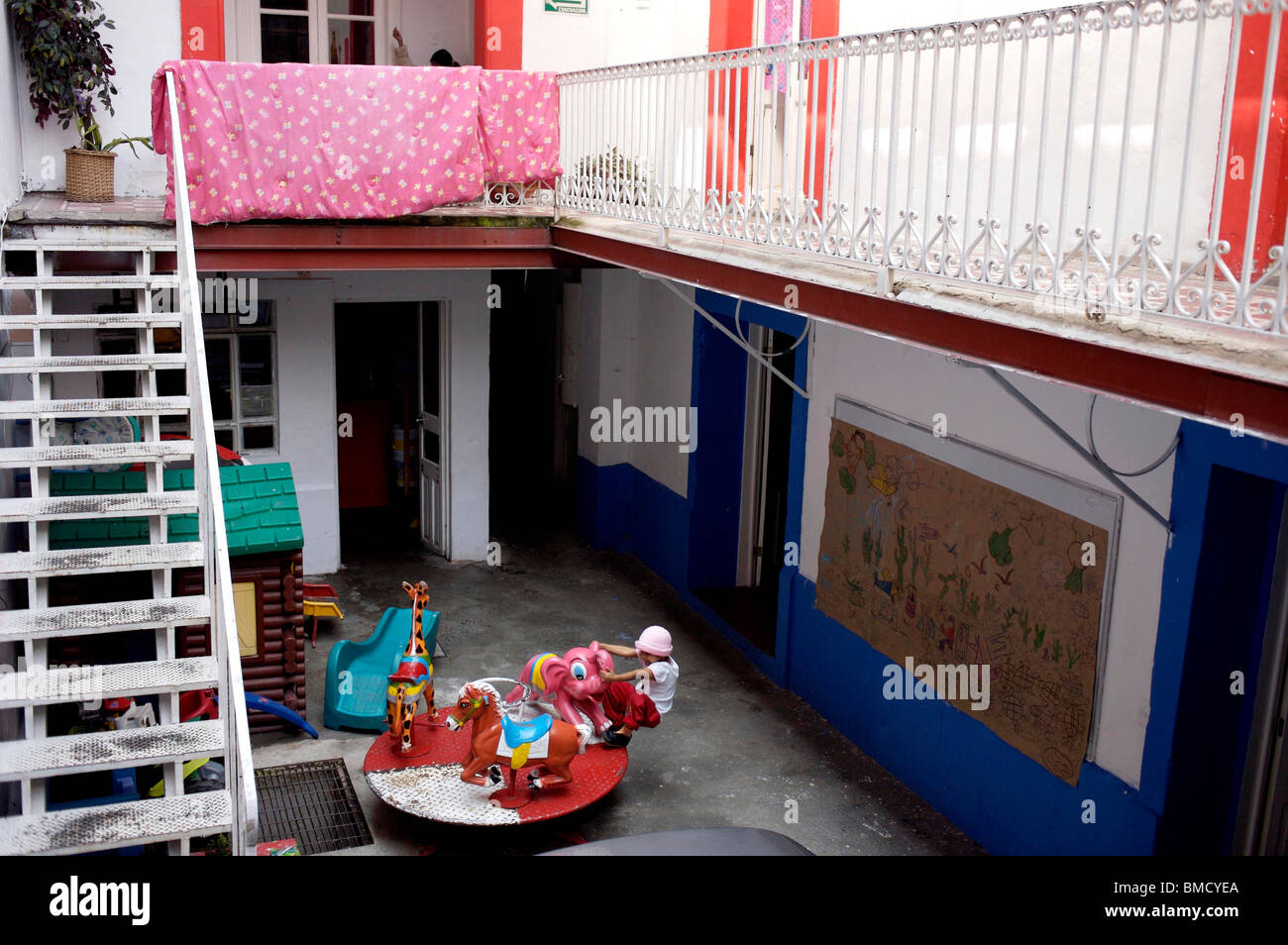 Une fille joue dans un abri pour des enfants souffrant d'exécuter par le clou de fondation dans la ville de Mexico Banque D'Images Une fille joue dans un abri pour des enfants souffrant d'exécuter par le clou de fondation dans la ville de Mexico Banque D'Images