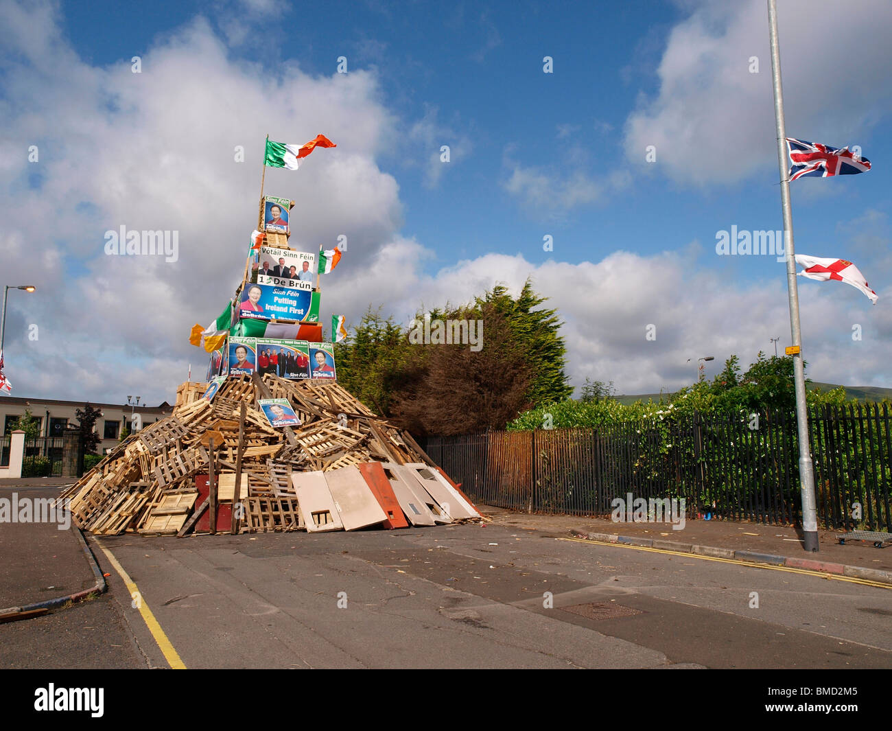 11e nuit feu loyaliste décoré avec le drapeau irlandais et des affiches électorales d'hommes politiques nationalistes. Banque D'Images