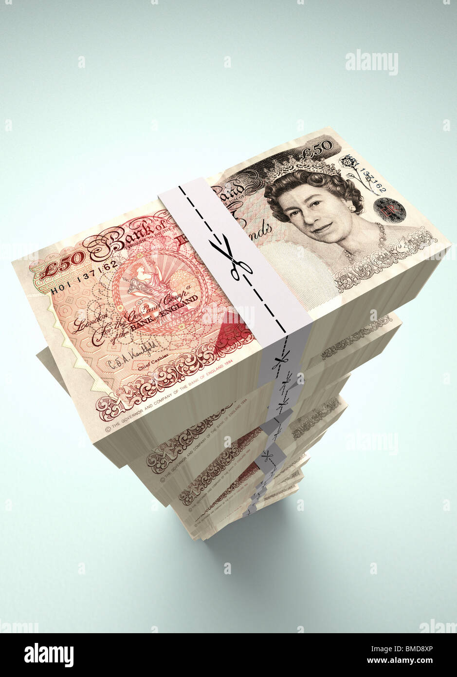 50 € grandes piles de livres de billets de banque britannique avec des ciseaux coupe le long des liens de l'argent. Ce qui représente une réduction des dépenses. Banque D'Images
