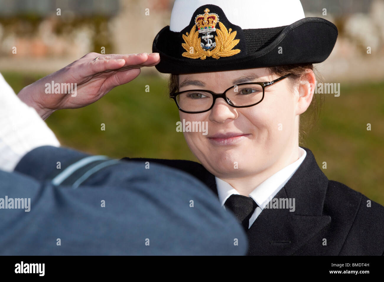 Jeune femme officier de marine rend hommage à un officier cadet corp saluting Banque D'Images