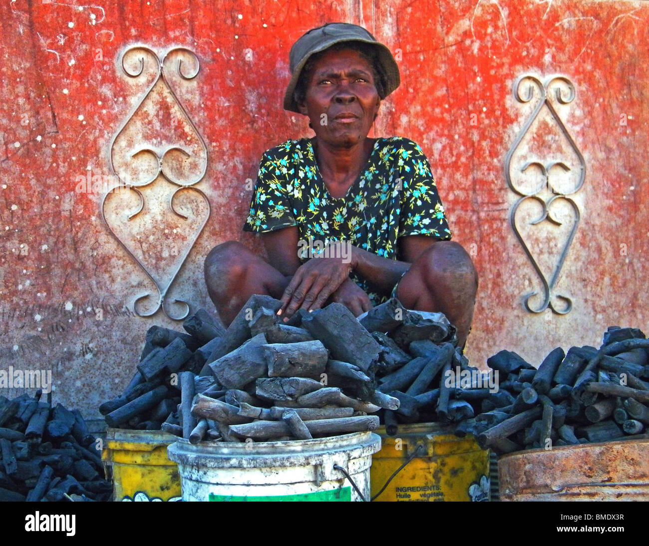 Une femme vend du charbon dans la rue à Gonaïves, Haïti, où le déboisement pour le carburant est un problème. Banque D'Images