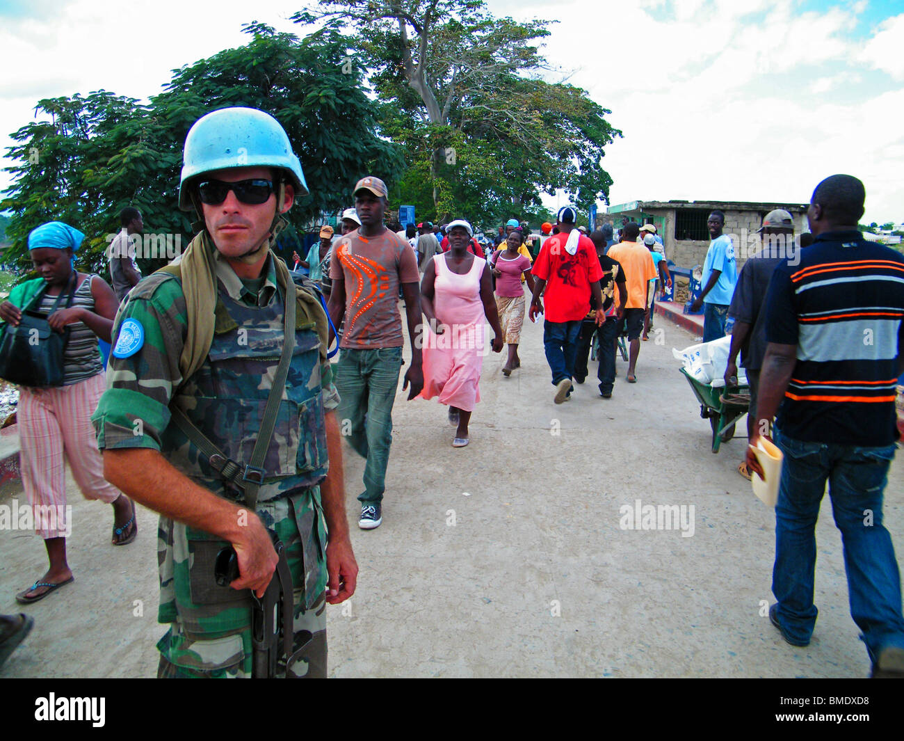 Un casque bleu des Nations Unies veille sur e Haïti - République dominicaine de passage frontalier à Dajabon, pendant le marché hebdomadaire Banque D'Images