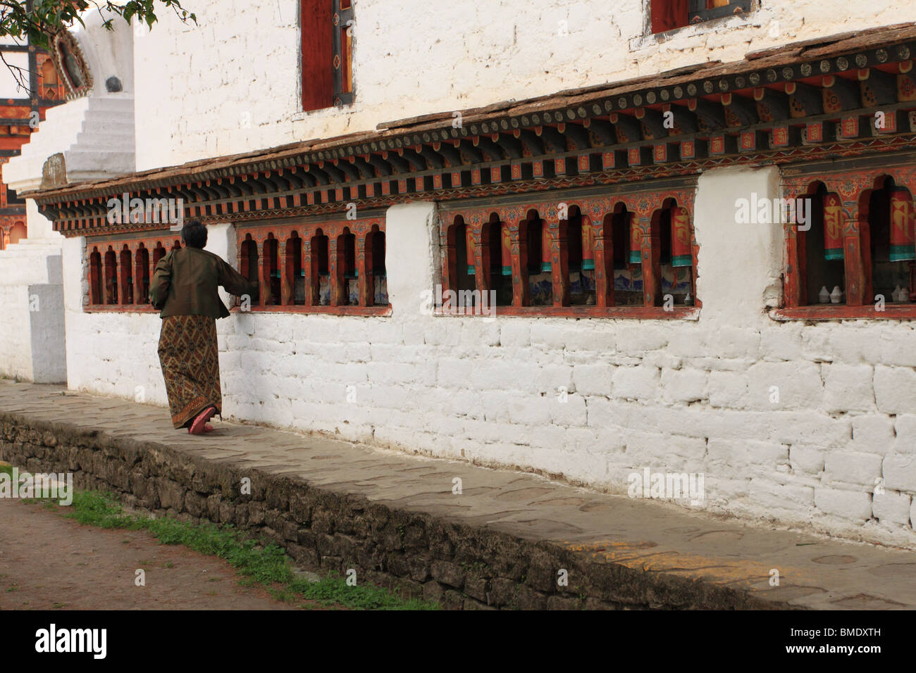 Femme de tourner les roues de prière bhoutanais à Kyichu Lhakhang Paro Bhoutan Banque D'Images