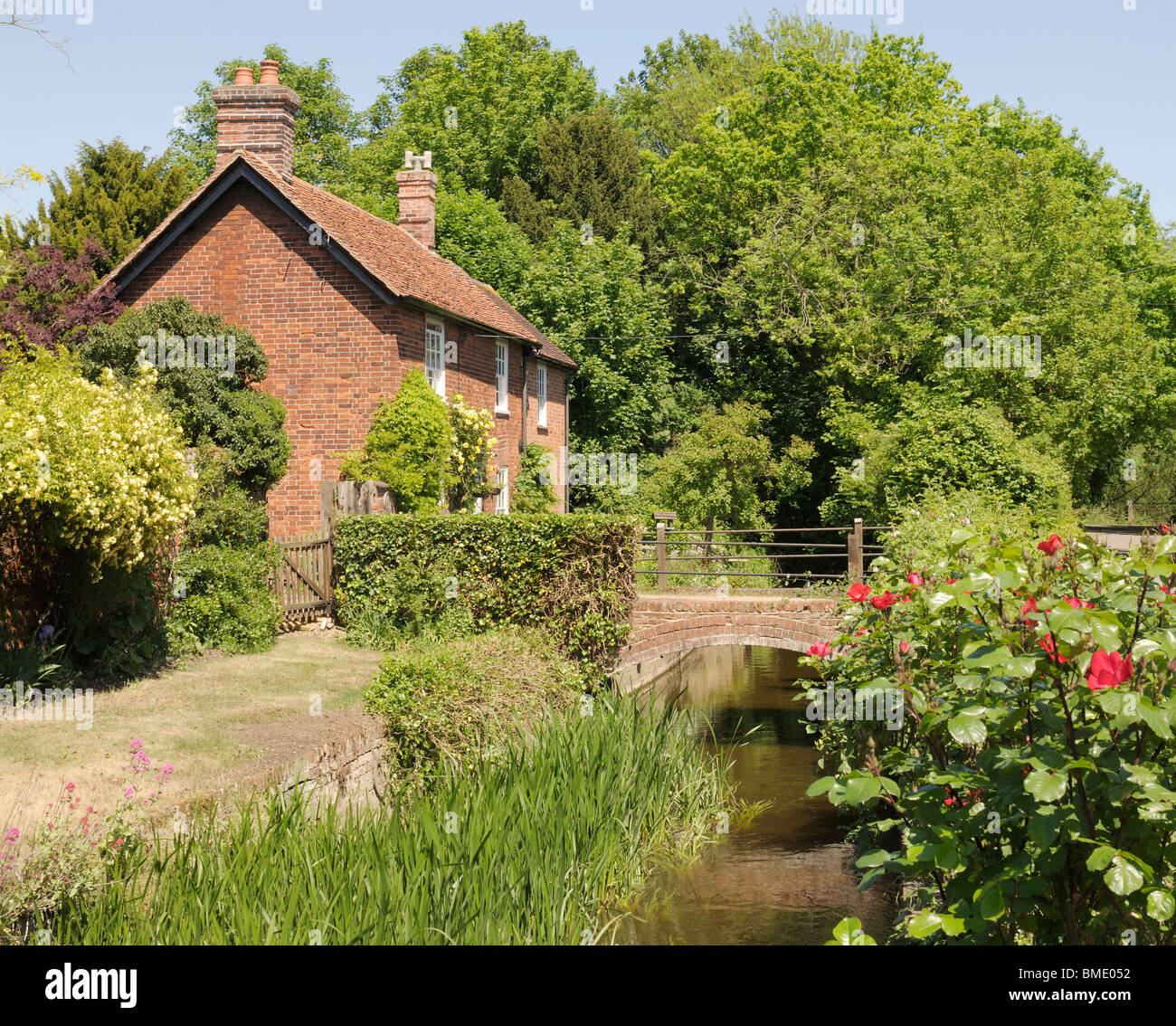 Une petite maison à côté d'une rivière dans le Nayland, un village de Suffolk, Angleterre. Banque D'Images