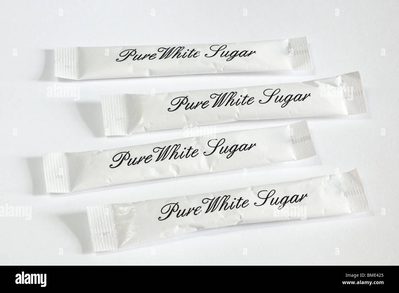 Quatre sachets de sucre blanc pur Banque D'Images