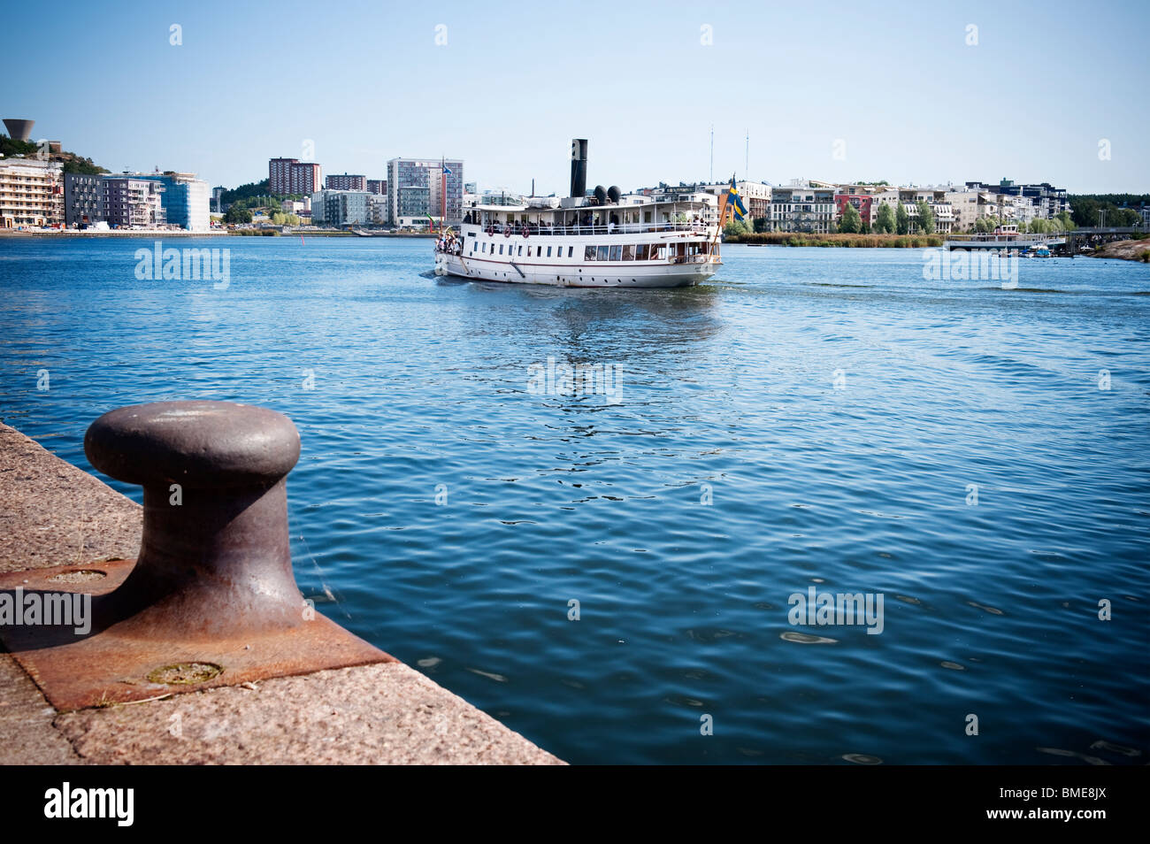 Chemise de vapeur sur mer, cityscape in background Banque D'Images