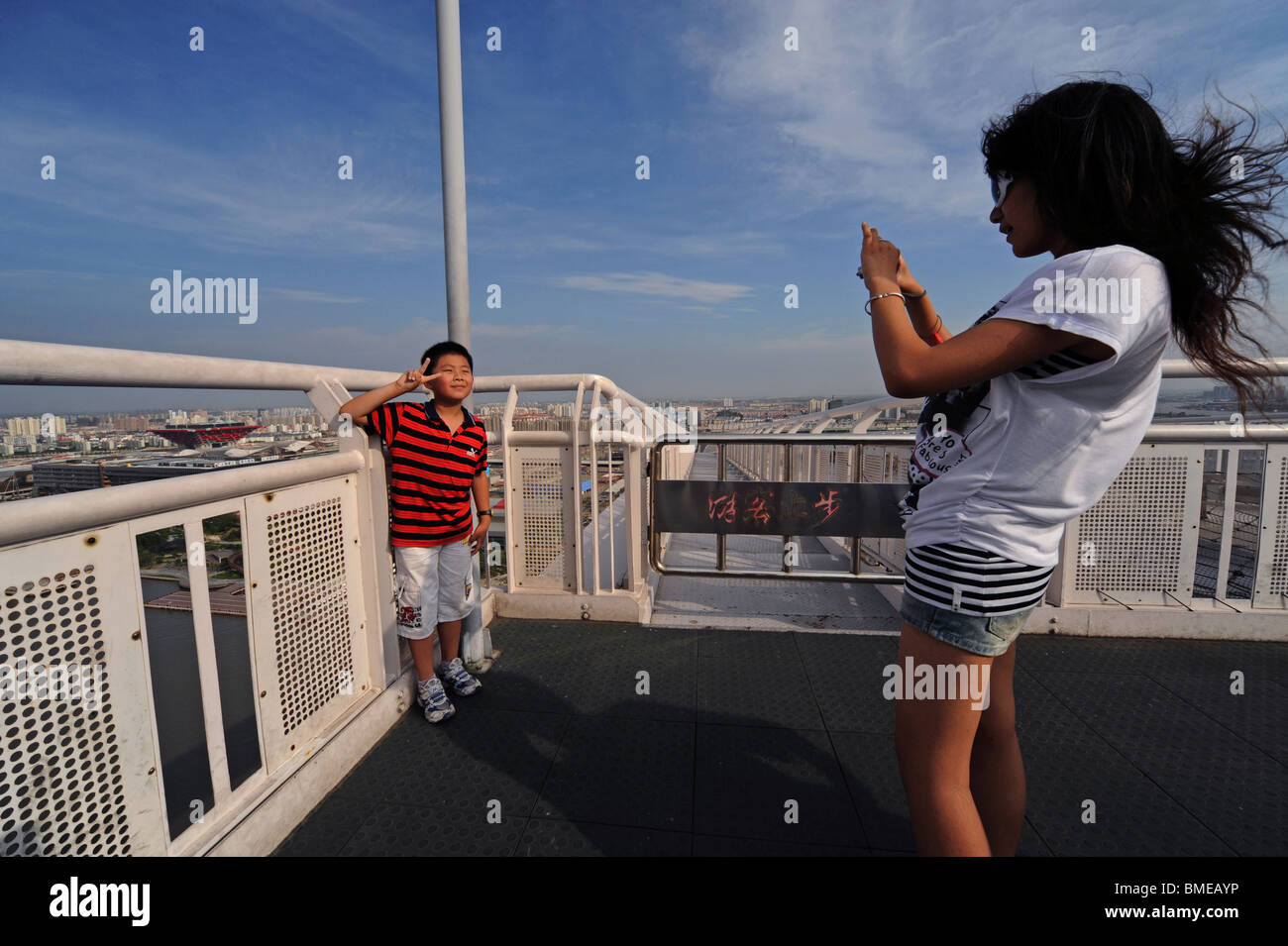 Garçon chinois prendre des photos à l'aide 2010 Shanghai World Expo Park comme arrière-plan de pont Lupu, Shanghai, Chine Banque D'Images