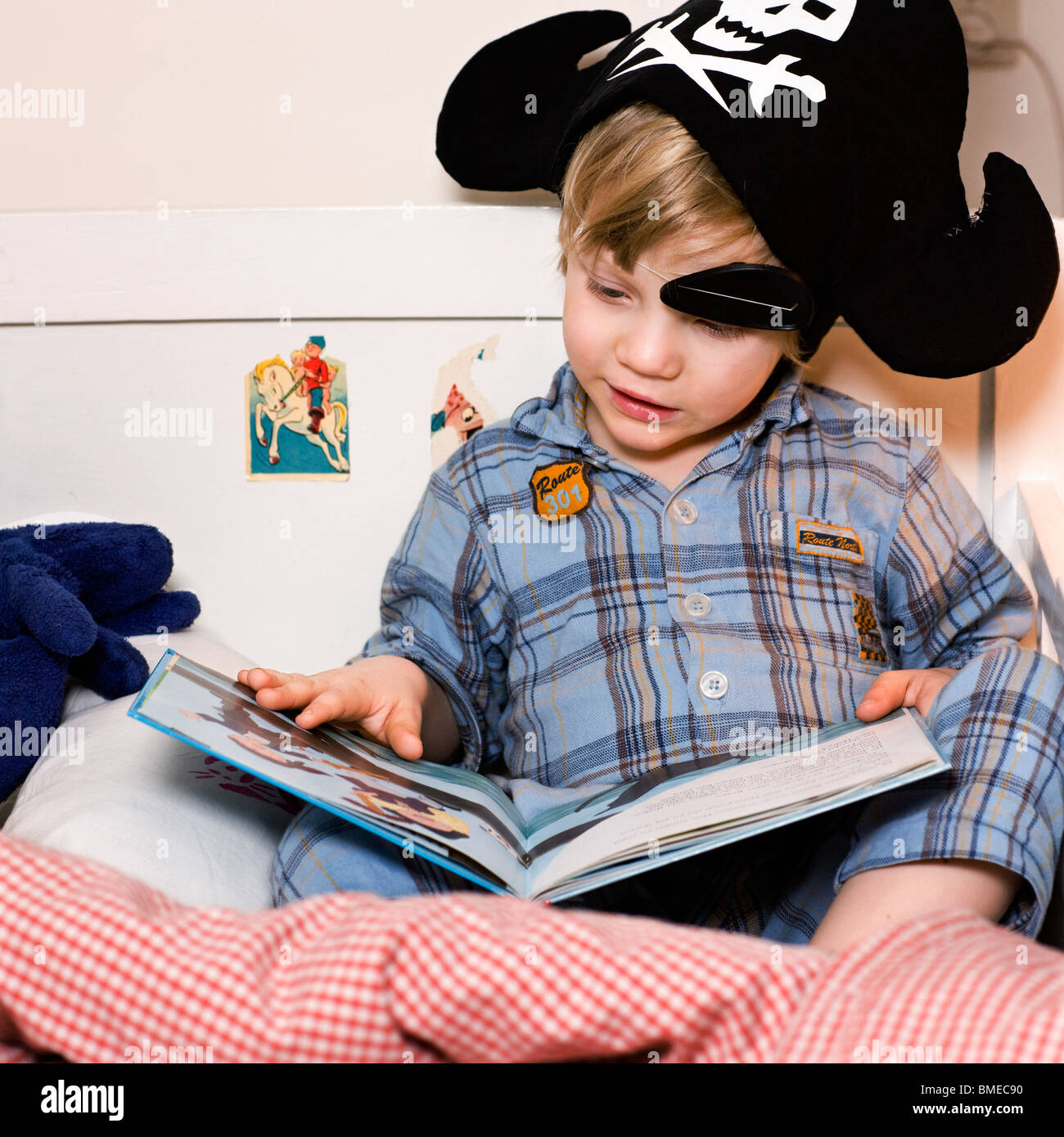 Boy reading book on bed Banque D'Images