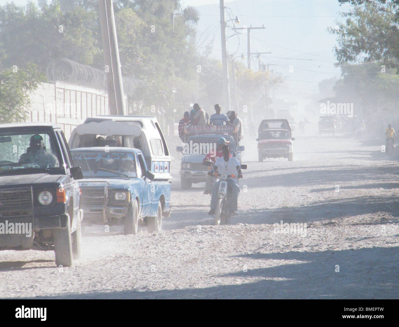 Entraînement des véhicules par l'entremise de l'nuages de poussières que Gonaïves invisible après l'inondation par les ouragans estompée, Haïti Banque D'Images