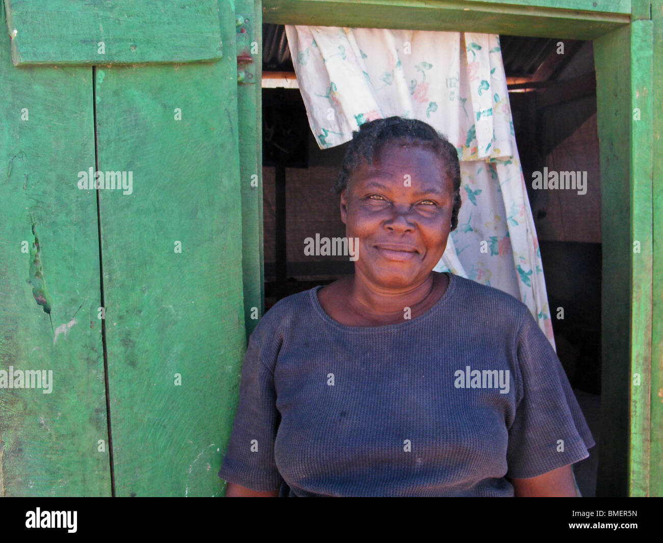 Une femme à la porte de son abri de fortune dans un camp de déplacés à l'extérieur de Gonaïves, Haïti, après la saison des ouragans de 2008) Banque D'Images