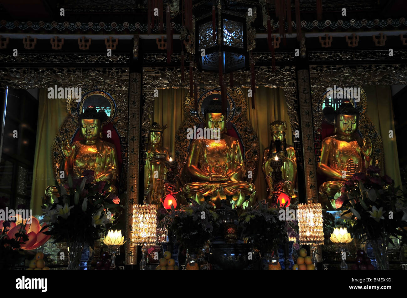 Trois statues de Bouddha d'or dans le Grand Hall du temple principal, le monastère Po Lin, Lantau Island, Hong Kong, Chine Banque D'Images