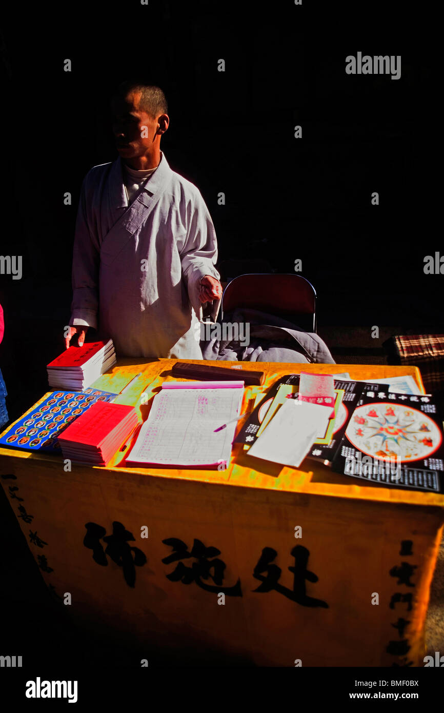 Monk se tenir à côté d'un stand de don, le Mont Wutai, Xinzhou City, province de Shanxi, Chine Banque D'Images